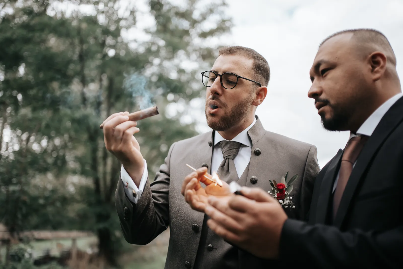 Der Bräutigam Massimo raucht nach dem Styling eine Zigarre mit seinem Trauzeugen – fotografiert by SB Snaps, Hochzeitsfotograf im Saarland